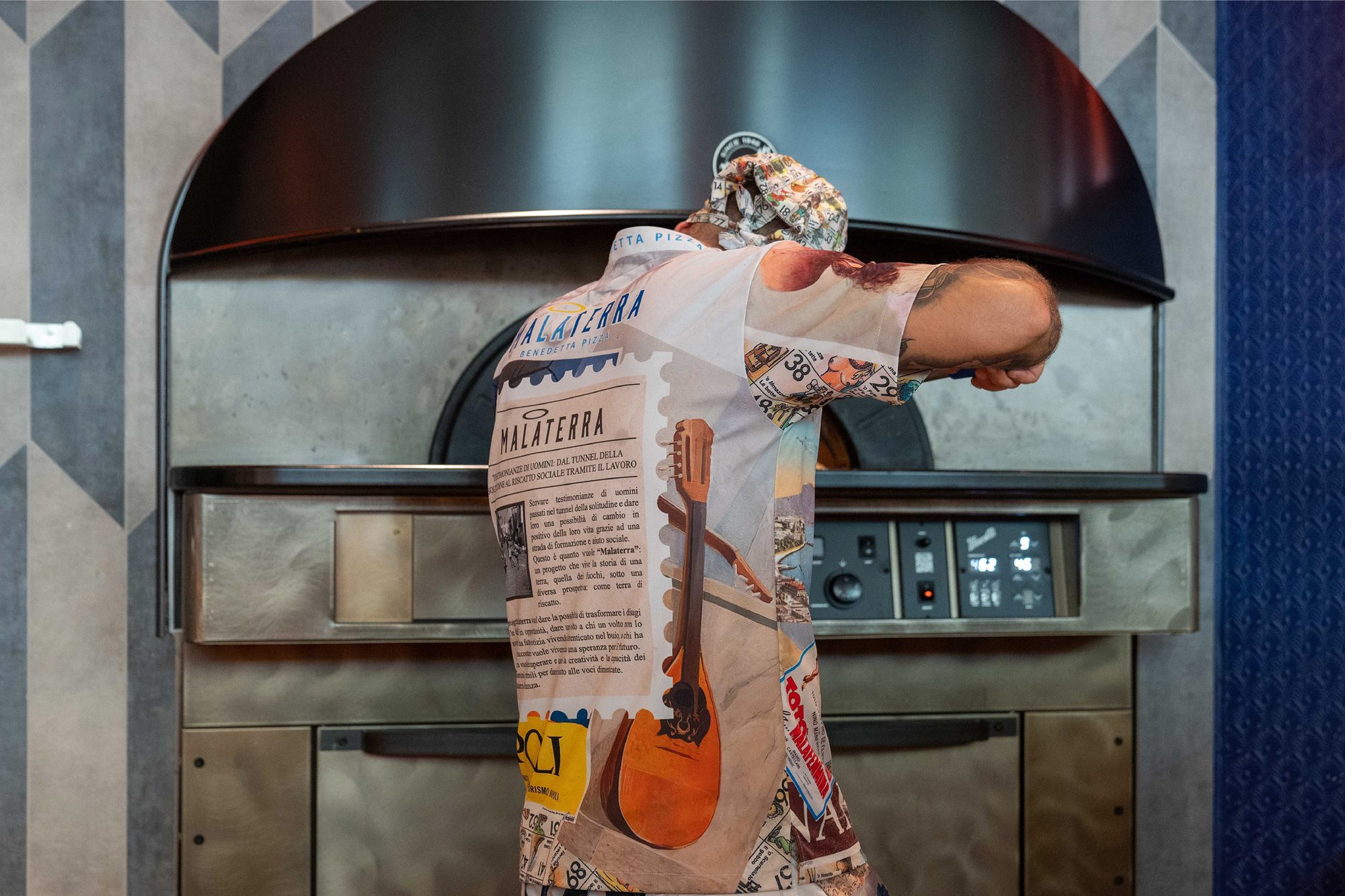 Pizza chef with branded uniform at the oven